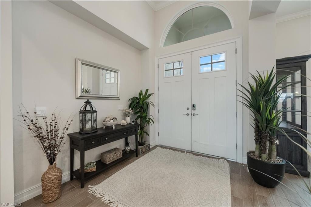 Image 4: Foyer entrance featuring crown molding and wood finished floors