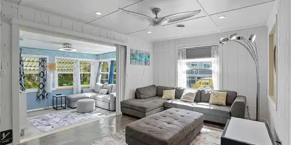 Image 4: Living area with recessed lighting, wood finished floors, ceiling fan, and wood walls - Virtually Edited Image