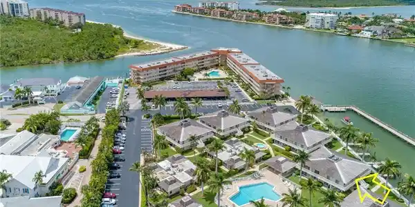 Image 4: View of urban area featuring a pool area and a nearby body of water
