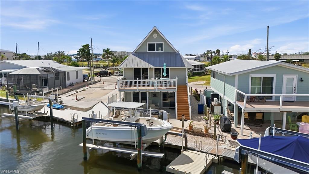 Image 2: Dock area with a patio area, boat lift, a water view, and a balcony