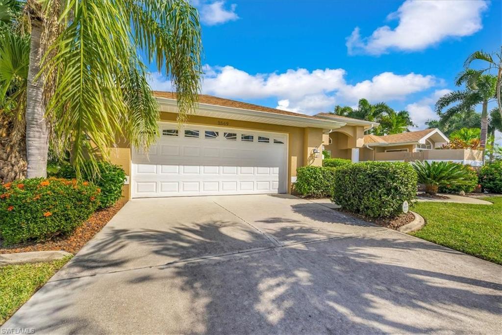 Image 3: View of front of home with stucco siding, driveway, and an attached garage
