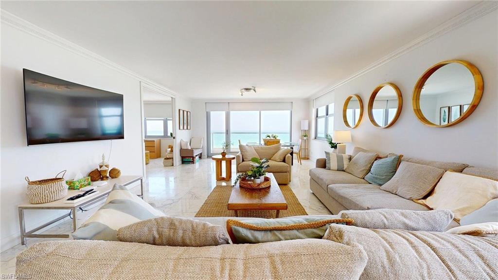 Image 3: Living room with crown molding, plenty of natural light, and marble finish floors