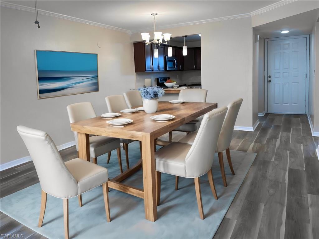 Image 4: Dining room featuring crown molding, a chandelier, and dark wood-style flooring