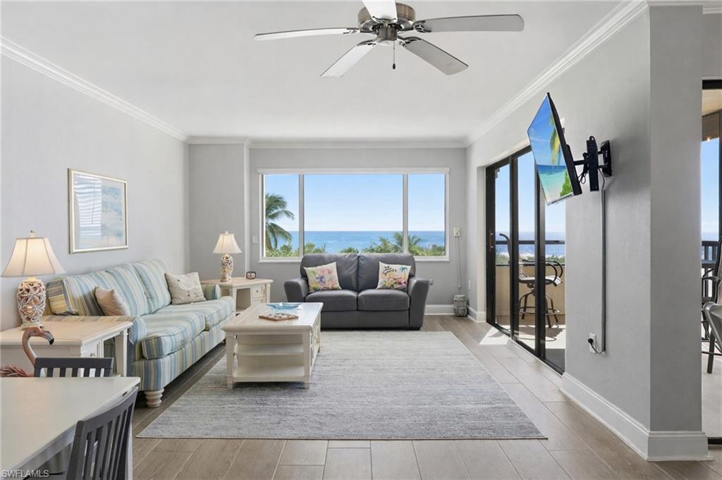 Image 2: Living room with a ceiling fan, light wood-style flooring, and crown molding