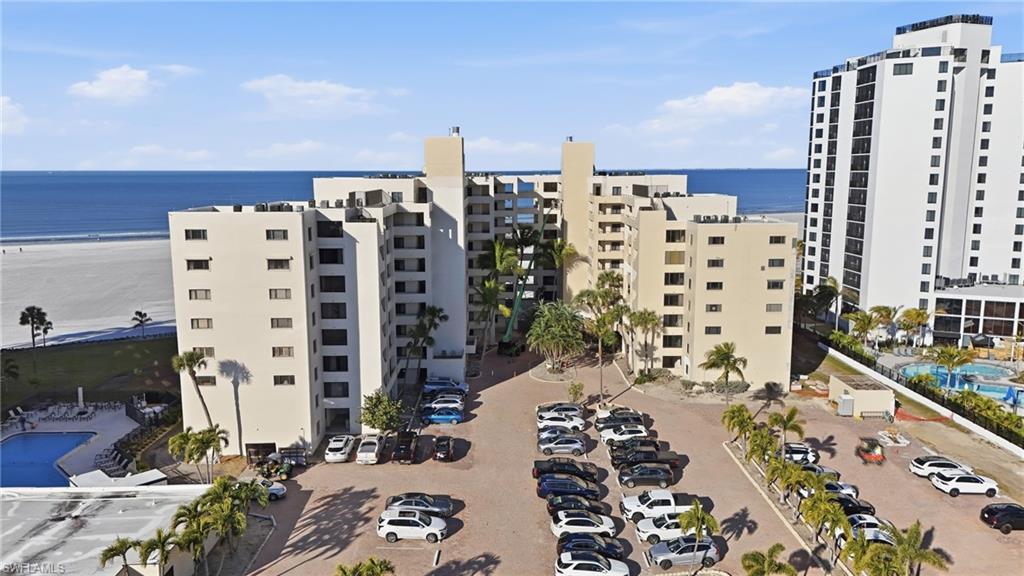 Image 3: View of apartment building / complex with a water view and uncovered parking