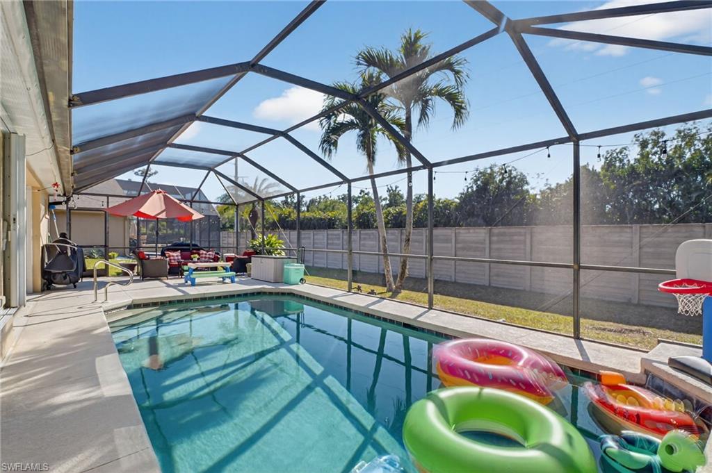 Image 1: View of swimming pool with a fenced backyard, a sunroom, a lanai, and patio surround