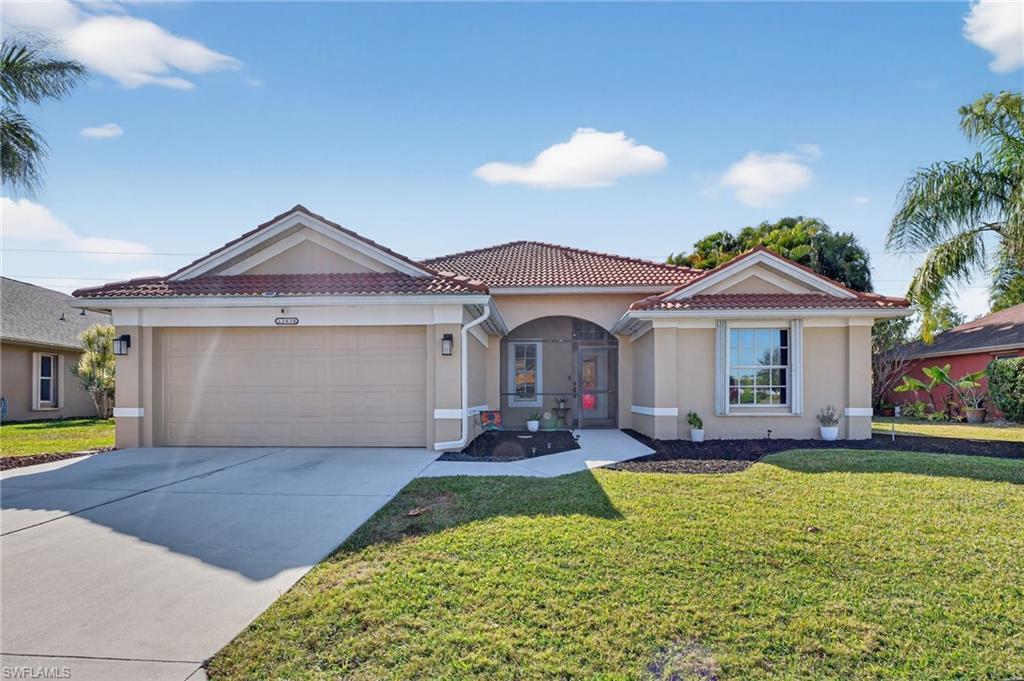 Image 3: Mediterranean / spanish house featuring a tiled roof, stucco siding, driveway, an attached garage, and a front lawn