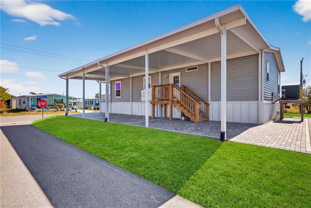 Image 3: Manufactured home featuring elevated home, driveway and elevated HVAC