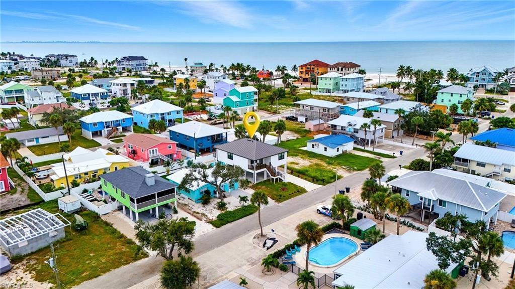 Image 2: Aerial view of residential area featuring a pool area and a large body of water - Virtually Edited Image