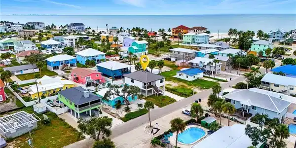 Image 2: Aerial view of residential area featuring a pool area and a large body of water - Virtually Edited Image