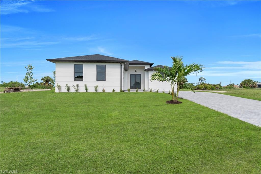 Image 3: View of front of property with a front yard, driveway, and an attached garage