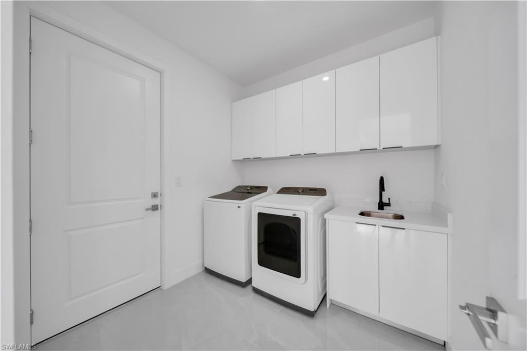 Image 4: Laundry room with cabinet space and independent washer and dryer