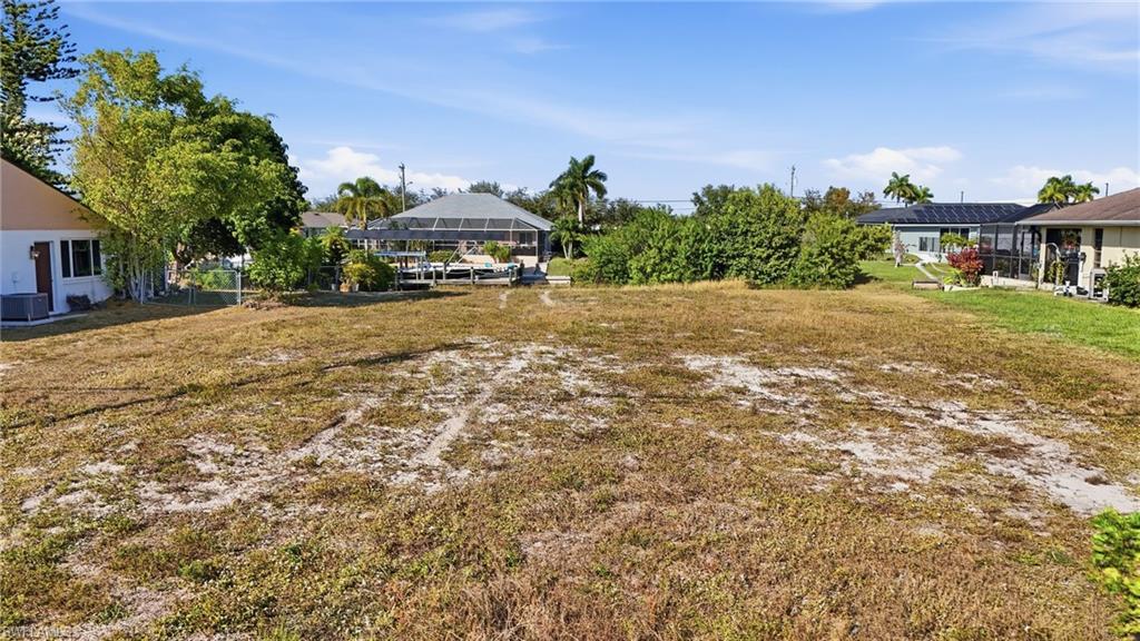 Image 4: View of grassy yard featuring a sunroom and a lanai