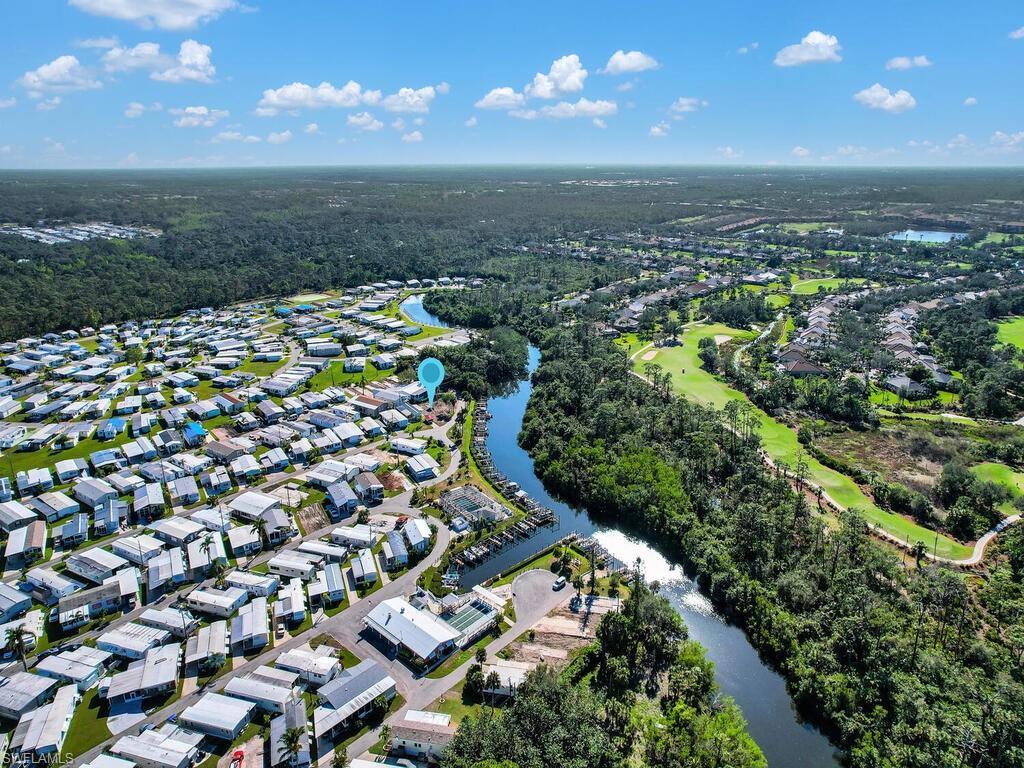Image 4: Aerial view of property and surrounding area featuring a nearby body of water and nearby suburban area
