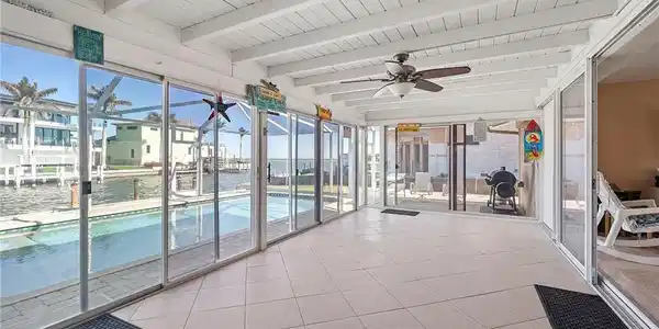 Image 2: Unfurnished sunroom featuring beamed ceiling, a water view, a healthy amount of sunlight, and ceiling fan