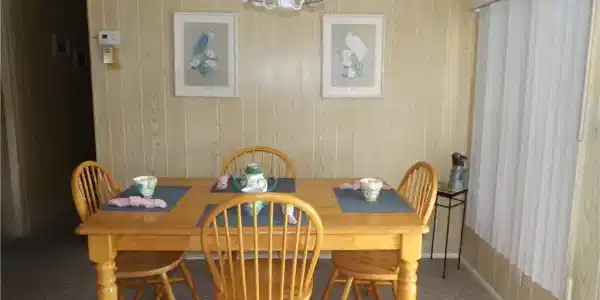 Image 3: Dining room featuring carpet flooring, wood walls, and a chandelier