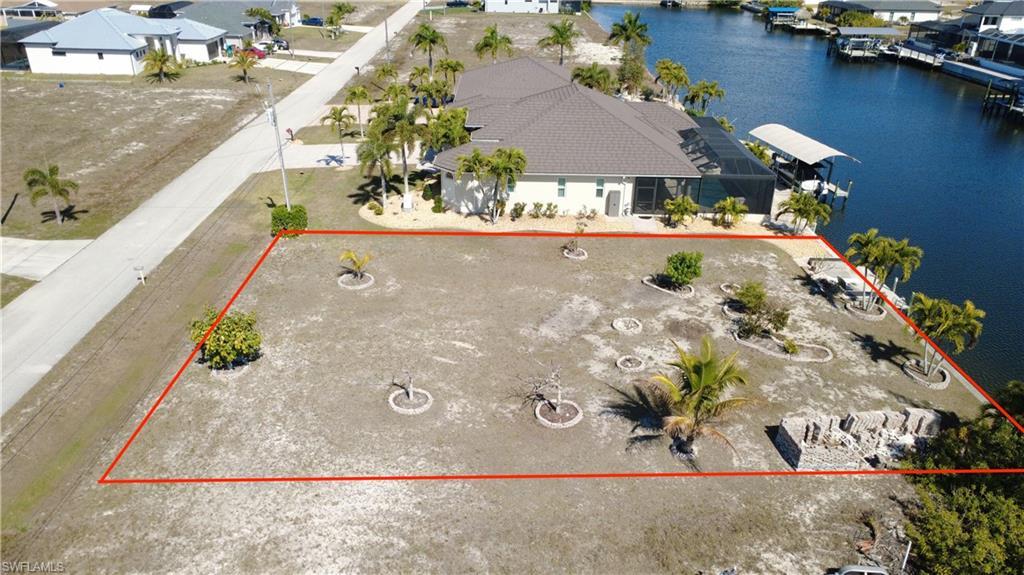 Image 2: Aerial perspective of suburban area with a large body of water and property parcel outlined