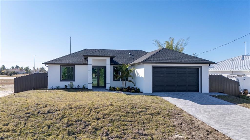 Image 1: Ranch-style house featuring stucco siding and a paver driveway