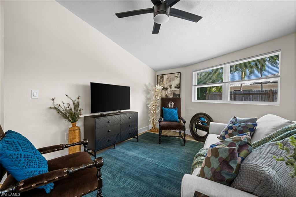 Image 3: Living area featuring vaulted ceiling and a ceiling fan