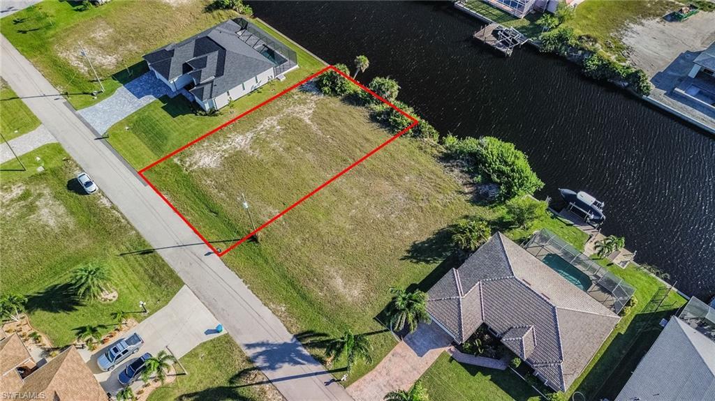 Image 4: View from above of property with property parcel outlined and a nearby body of water