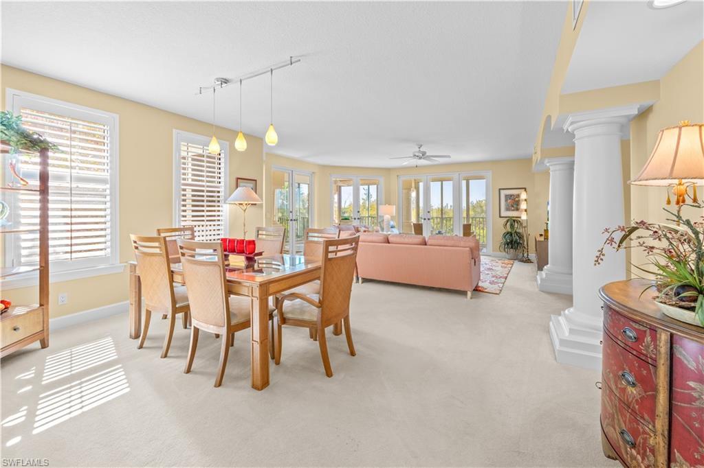 Image 2: Dining space featuring ornate columns, light carpet, rail lighting, and ceiling fan