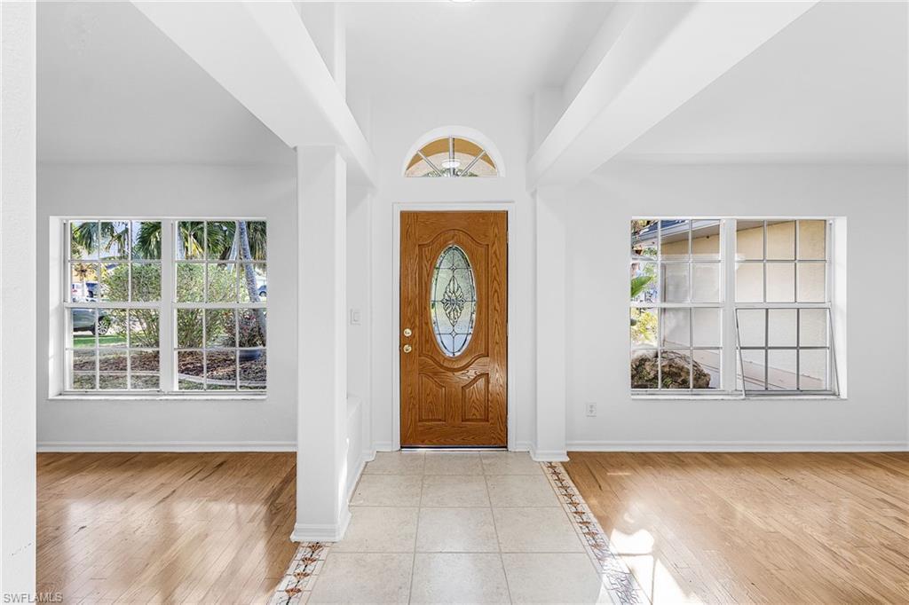 Image 4: Foyer entrance featuring light tile patterned flooring, plenty of natural light, inlaid floor details, and a high ceiling