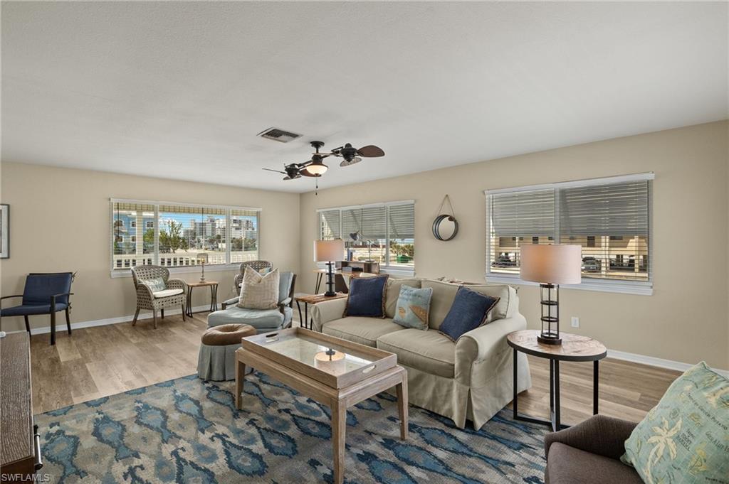 Image 2: Living area with a ceiling fan, baseboards, visible vents, and wood finished floors