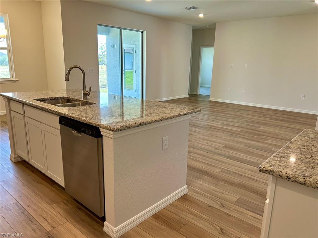 Image 3: Kitchen with dishwasher, a sink, light wood-style flooring, and healthy amount of natural light