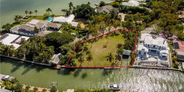 Image 2: Aerial perspective of suburban area featuring a nearby body of water and property parcel outlined