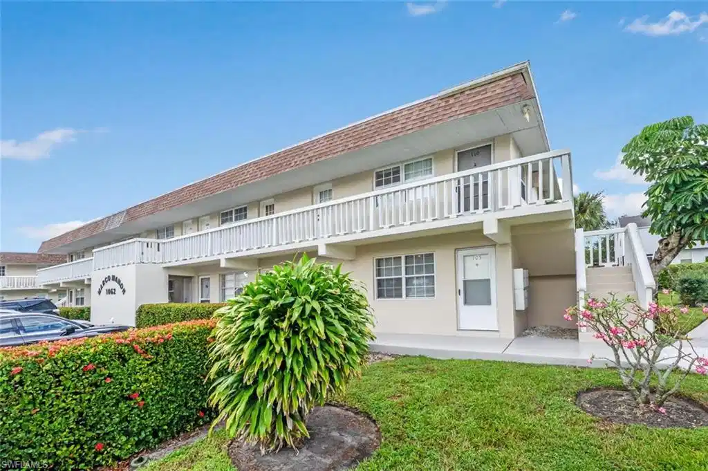 Image 1: Back of property with stucco siding and a balcony