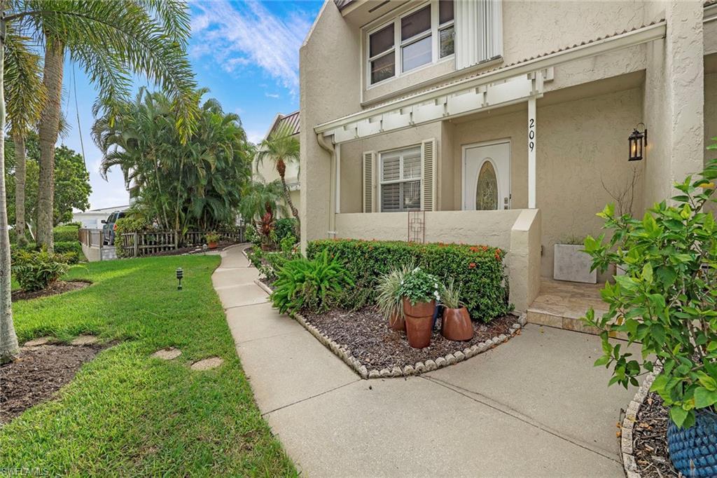 Image 4: View of exterior entry with stucco siding and a lawn