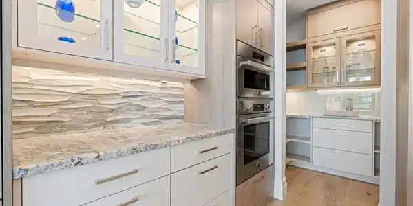Image 4: Kitchen featuring glass insert cabinets, light stone countertops, double oven, and modern cabinets