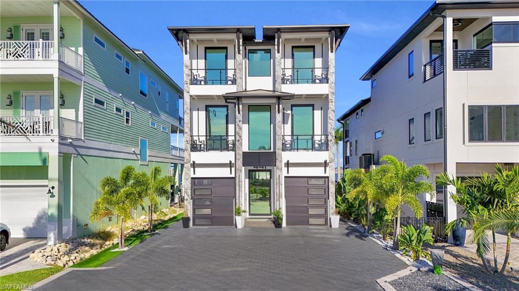 Image 3: Modern home with an attached garage, driveway, and stucco siding - Virtually Edited Image