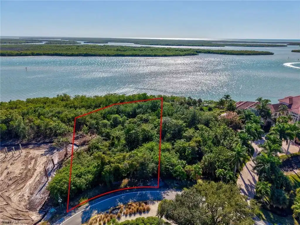 Image 1: Aerial overview of property's location with property parcel outlined and a large body of water