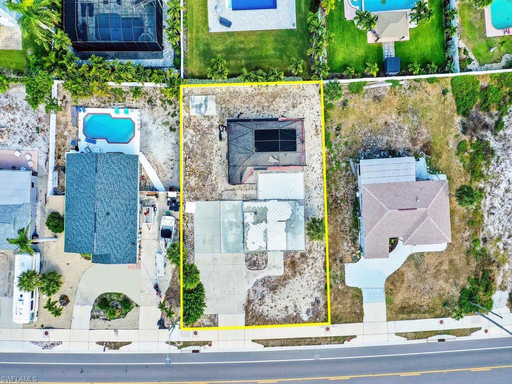 Image 2: Aerial view of property's location featuring a pool and property parcel outlined