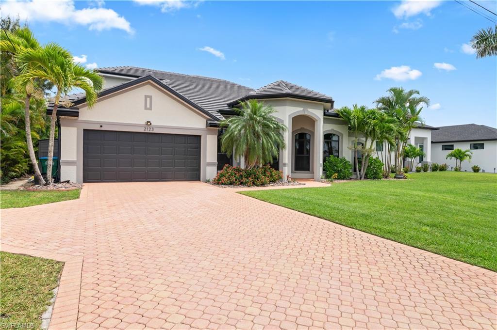 Image 2: Mediterranean / spanish-style house with a front yard, stucco siding, decorative driveway, and an attached garage