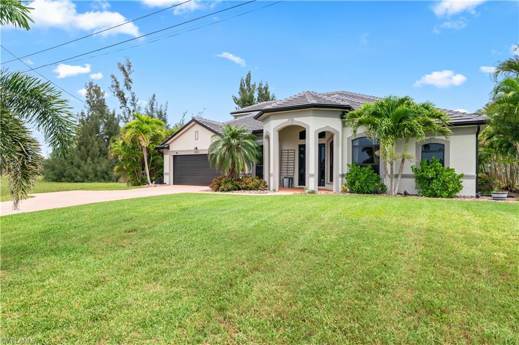 Image 3: Mediterranean / spanish-style house with concrete driveway, stucco siding, a front yard, and an attached garage