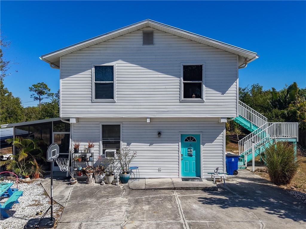 Image 2: View of front of property featuring stairway and a patio area