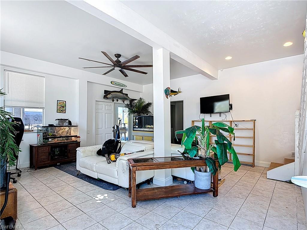 Image 3: Living room with ceiling fan, light tile patterned floors, and recessed lighting