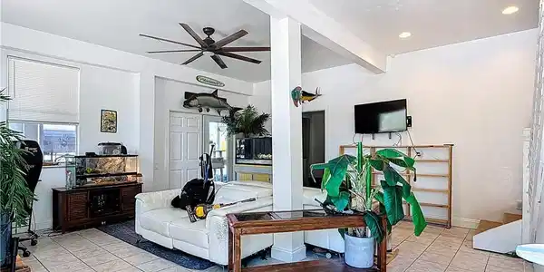 Image 3: Living room with ceiling fan, light tile patterned floors, and recessed lighting
