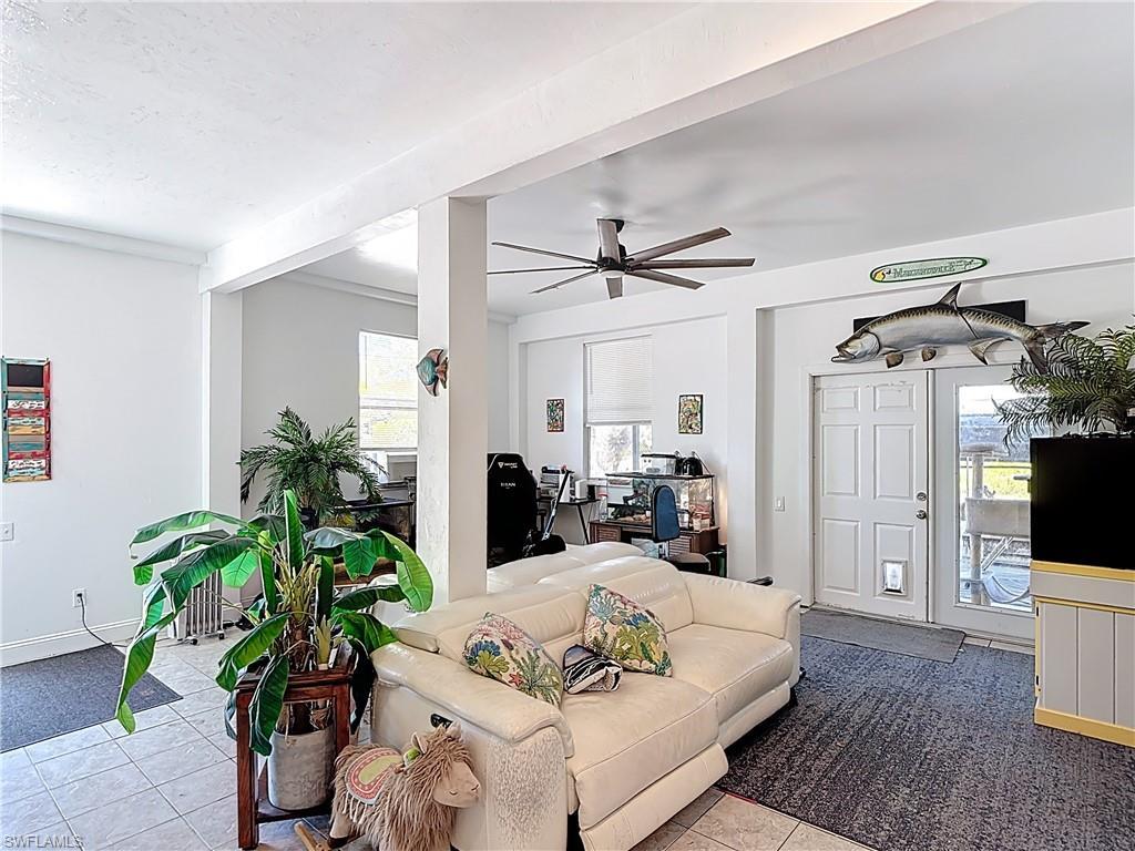 Image 4: Living area featuring a ceiling fan and tile patterned flooring