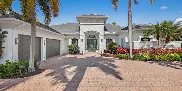 Image 2: View of front of home with decorative driveway, stucco siding, an attached garage, and french doors