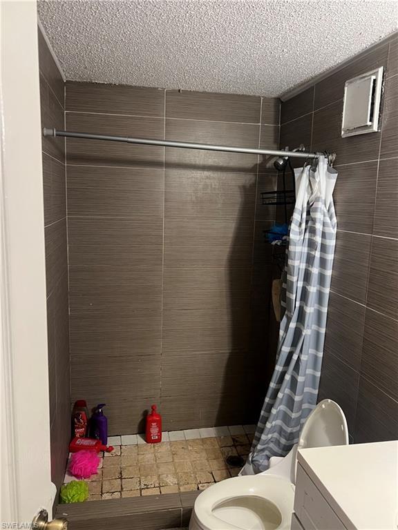 Image 3: Bathroom featuring a shower stall, vanity, and a textured ceiling