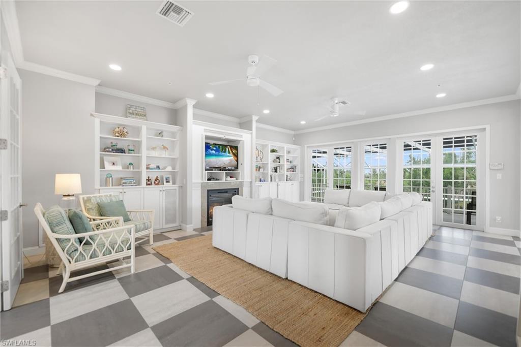 Image 4: Living room with ornamental molding, recessed lighting, ceiling fan, a glass covered fireplace, and light flooring