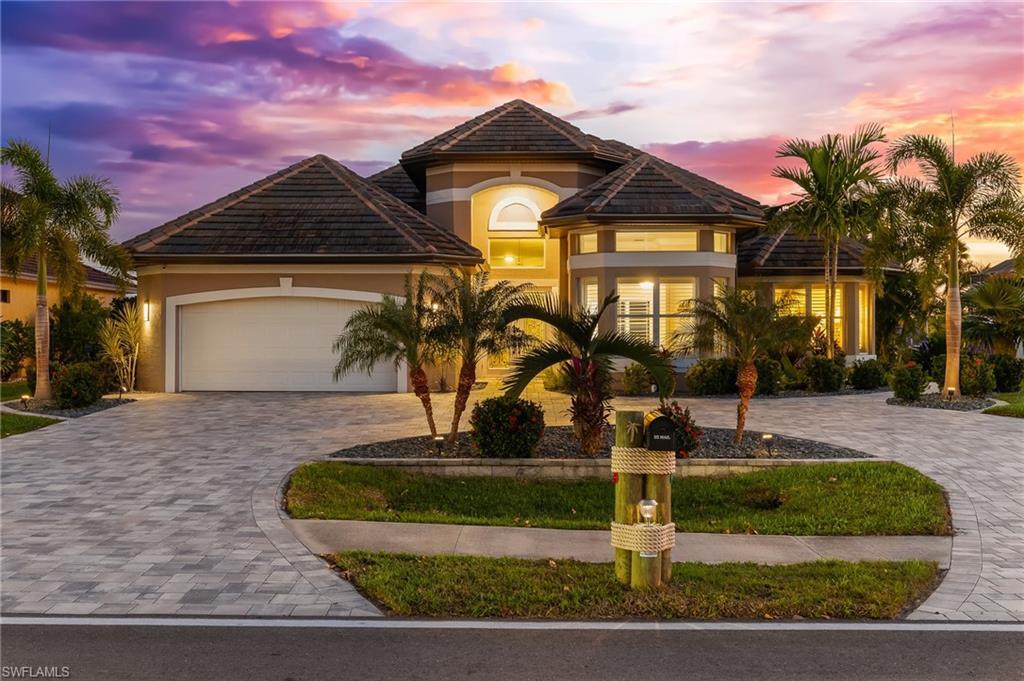 Image 3: Mediterranean / spanish-style home featuring decorative driveway, stucco siding, an attached garage, and a tile roof