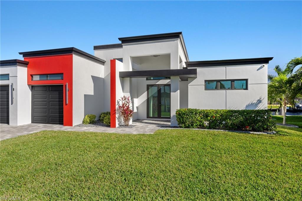 Image 1: Contemporary home with a front yard, stucco siding, and french doors