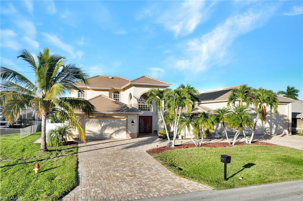 Image 4: Mediterranean / spanish house featuring decorative driveway, a front lawn, stucco siding, and a garage