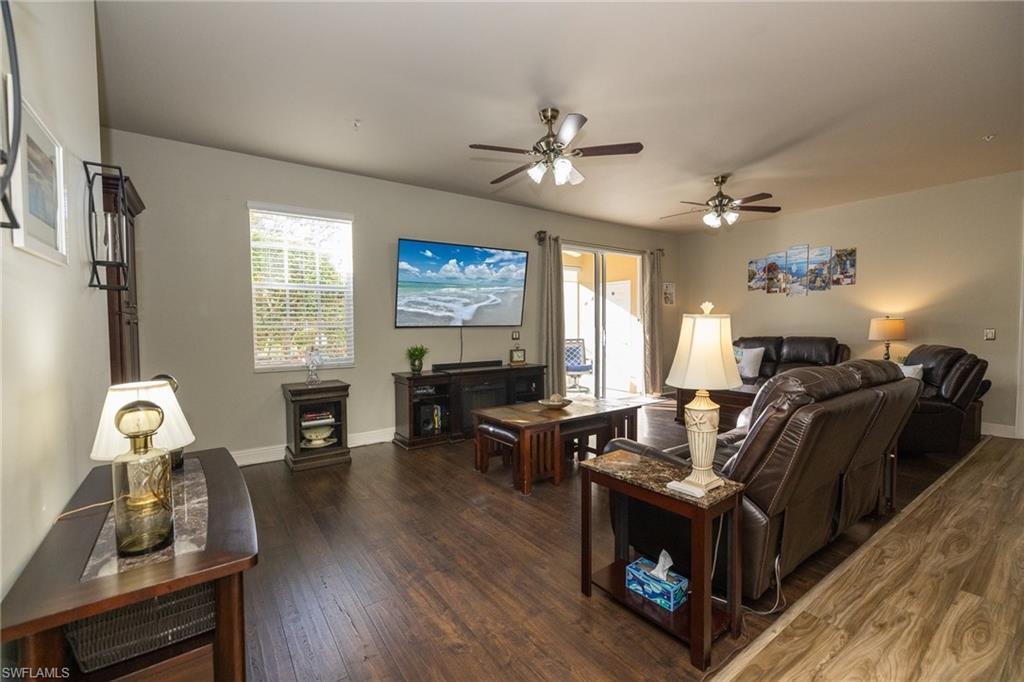Image 3: Living room with dark wood finished floors, ceiling fan, and plenty of natural light