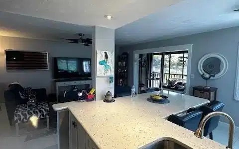 Image 2: Kitchen with light stone counters, open floor plan, light tile patterned flooring, a ceiling fan, and a textured ceiling