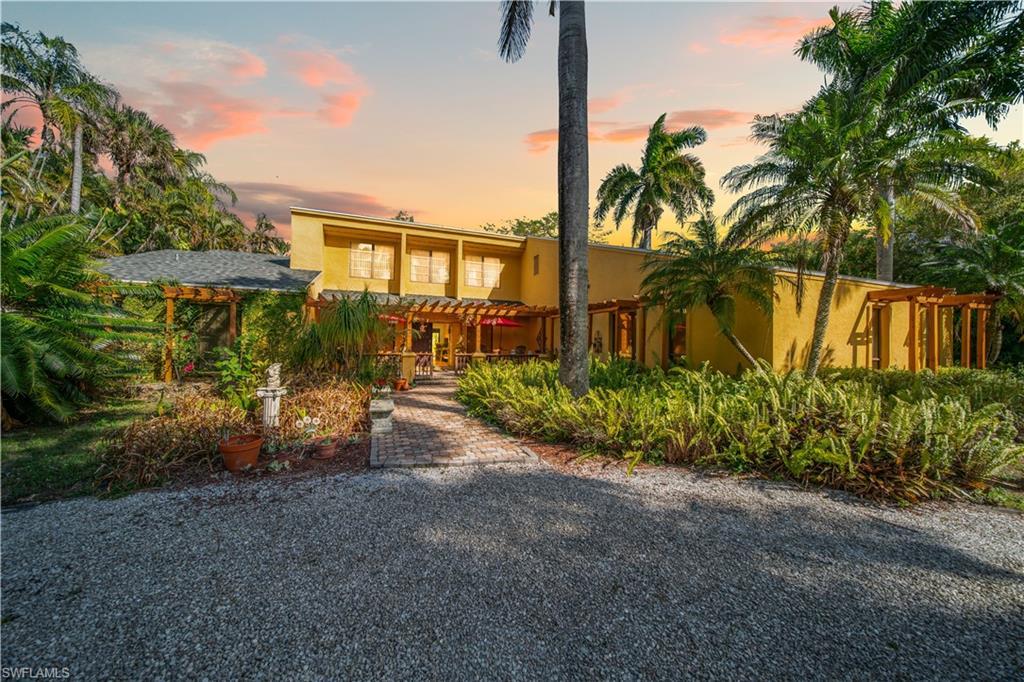Image 1: View of front of house featuring stucco siding and a pergola